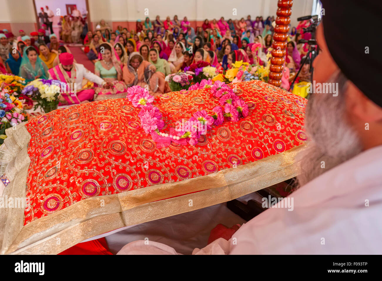 Prêtre Sikh assis à Veillée avec Guru Granth Sahib Saint Livre Banque D'Images