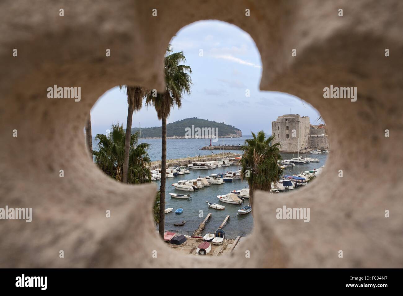 Vue sur le port et l'île à travers de la fenêtre meurtrière mur de la ville de Dubrovnik, Croatie Banque D'Images