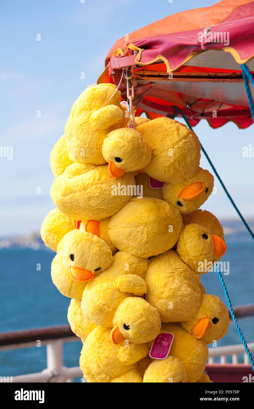 Jaune Suspendu canards jouets moelleux comme prix dans des expositions, wc séparés sur la jetée de Bournemouth en Août Banque D'Images