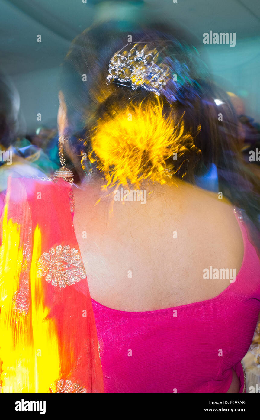 Les femmes indiennes en saris colorés Dancing at Wedding Reception Banque D'Images