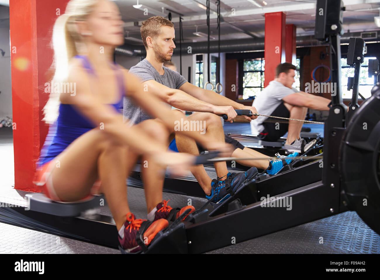Cours de gymnastique travaillant sur des machines à ramer ensemble Banque D'Images