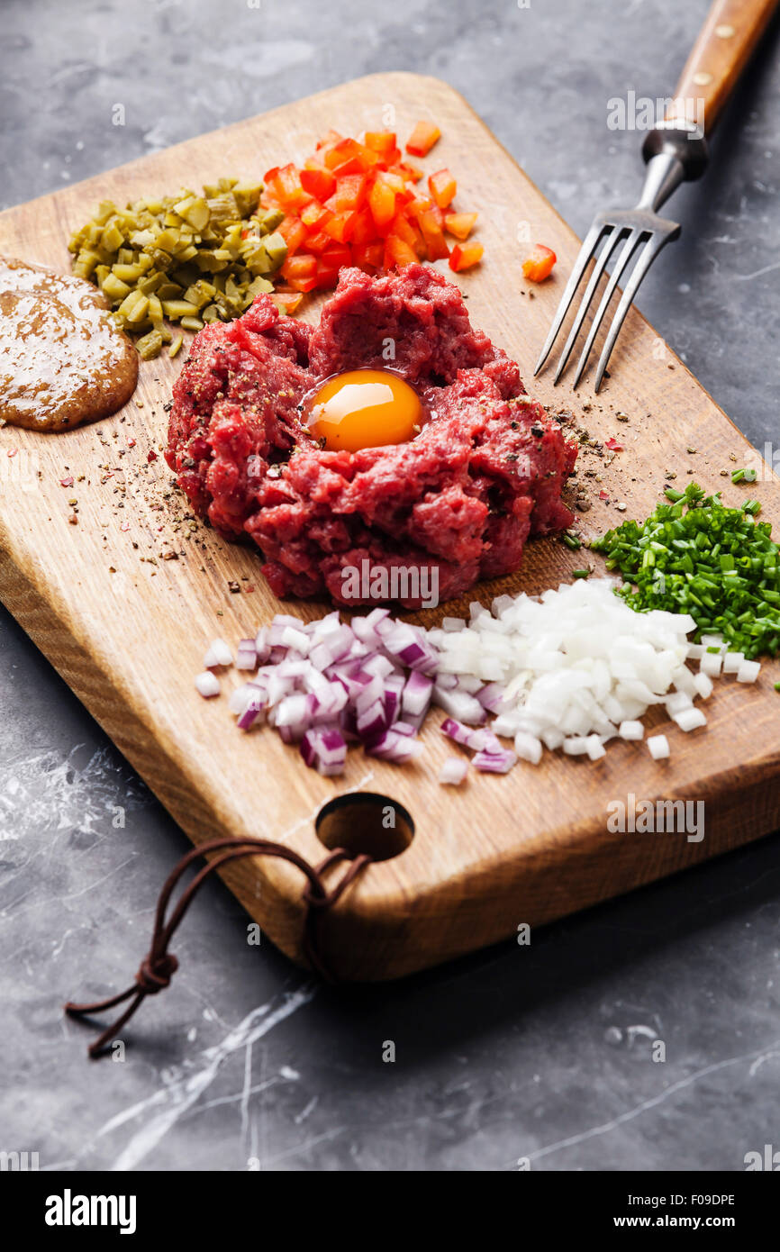 Tartare de boeuf cornichon et oignons frais sur fond de marbre noir Banque D'Images