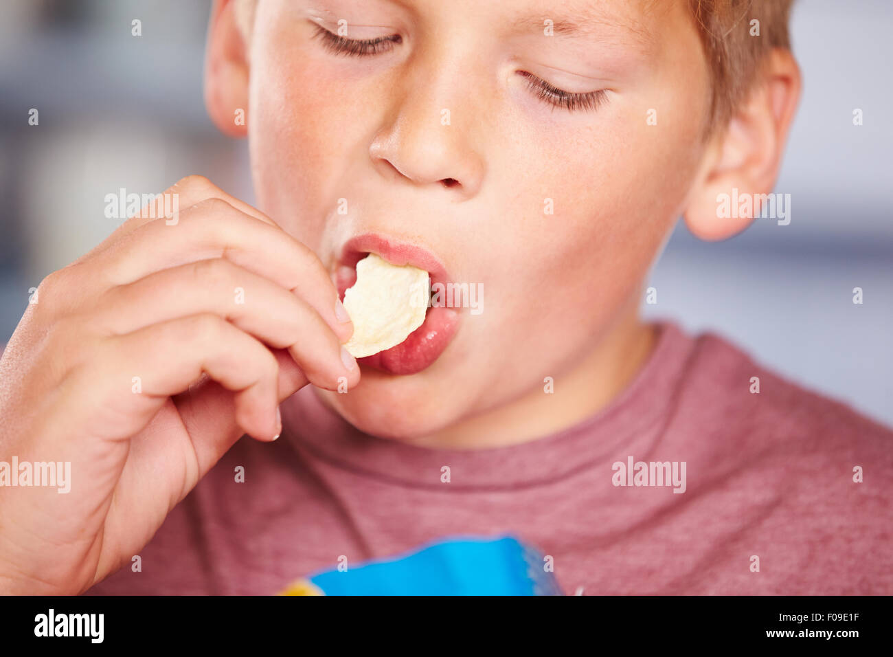 Close Up of Boy Eating paquet de chips Banque D'Images