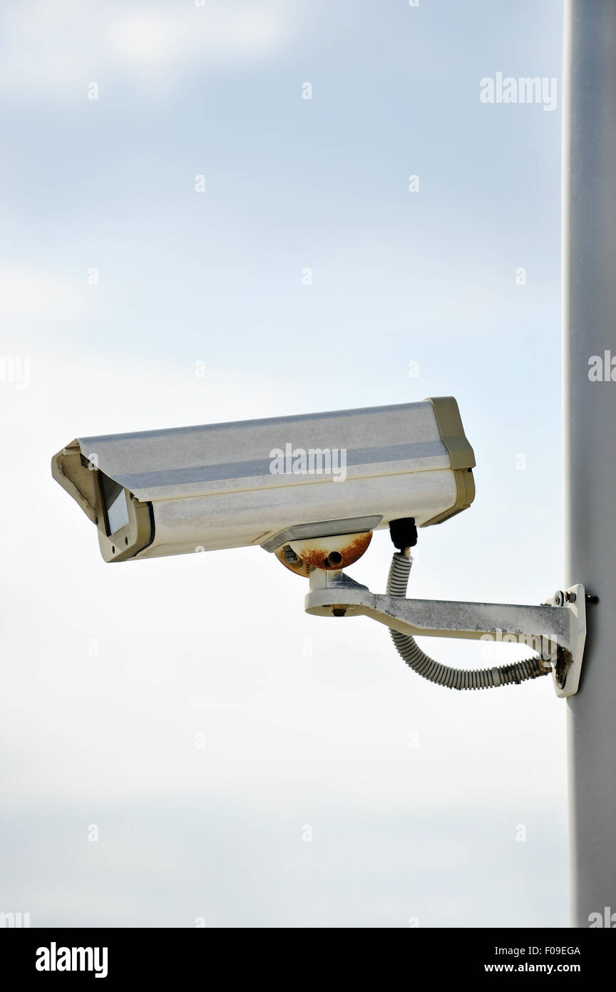 Une caméra de surveillance sur un poteau avec ciel bleu sur l'arrière-plan Banque D'Images