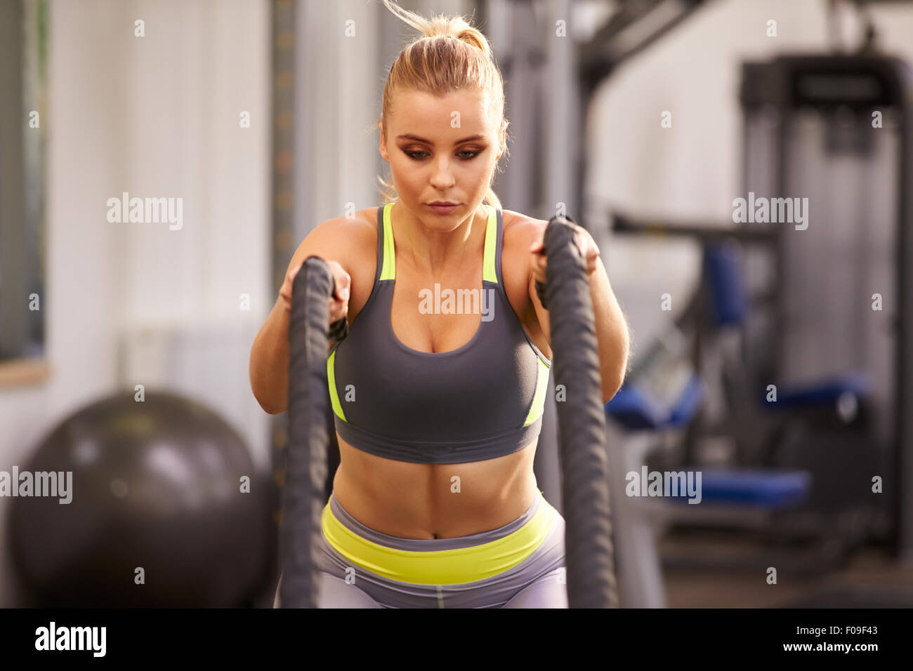 Jeune femme se préparent à travailler avec des cordes de combat dans une salle de sport Banque D'Images