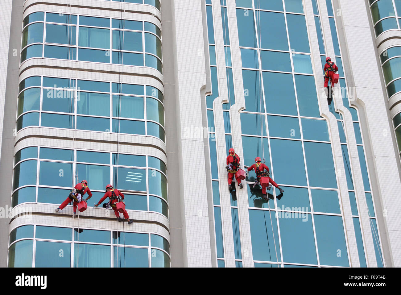 Les travailleurs du nettoyage de façade en action sur un gratte-ciel à l'aide du Bosuns Président et RDS (Système de descente de la corde)- un coup de Abu Dhabi Banque D'Images