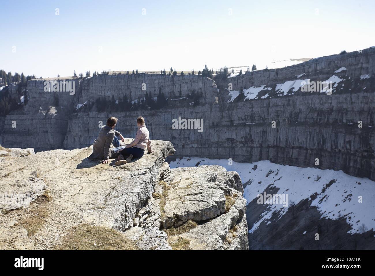 Couple assis sur les rochers à la recherche à Canton, Jura, Ecosse Banque D'Images