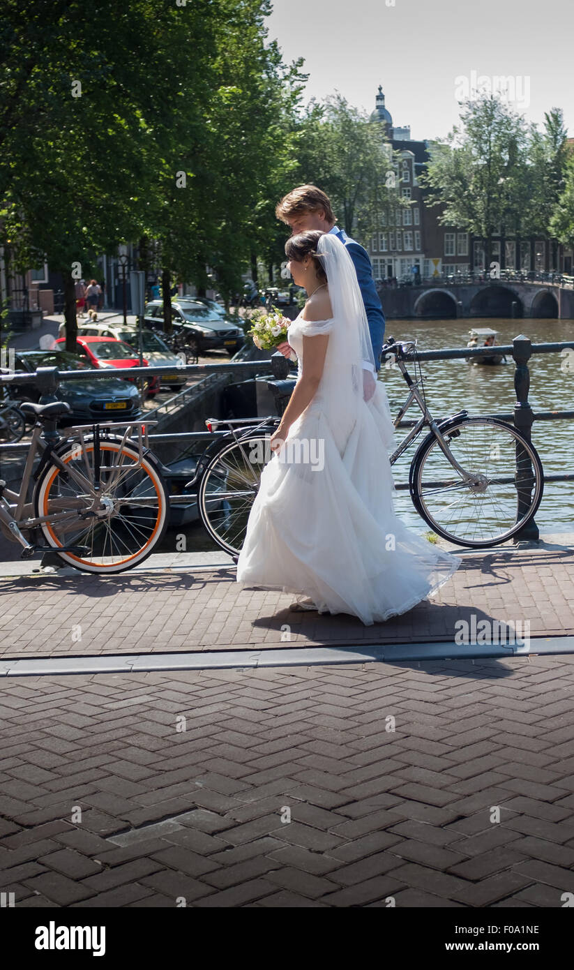 Un couple nouvellement marié à pied sur un pont-canal à Amsterdam après leur cérémonie de mariage Banque D'Images