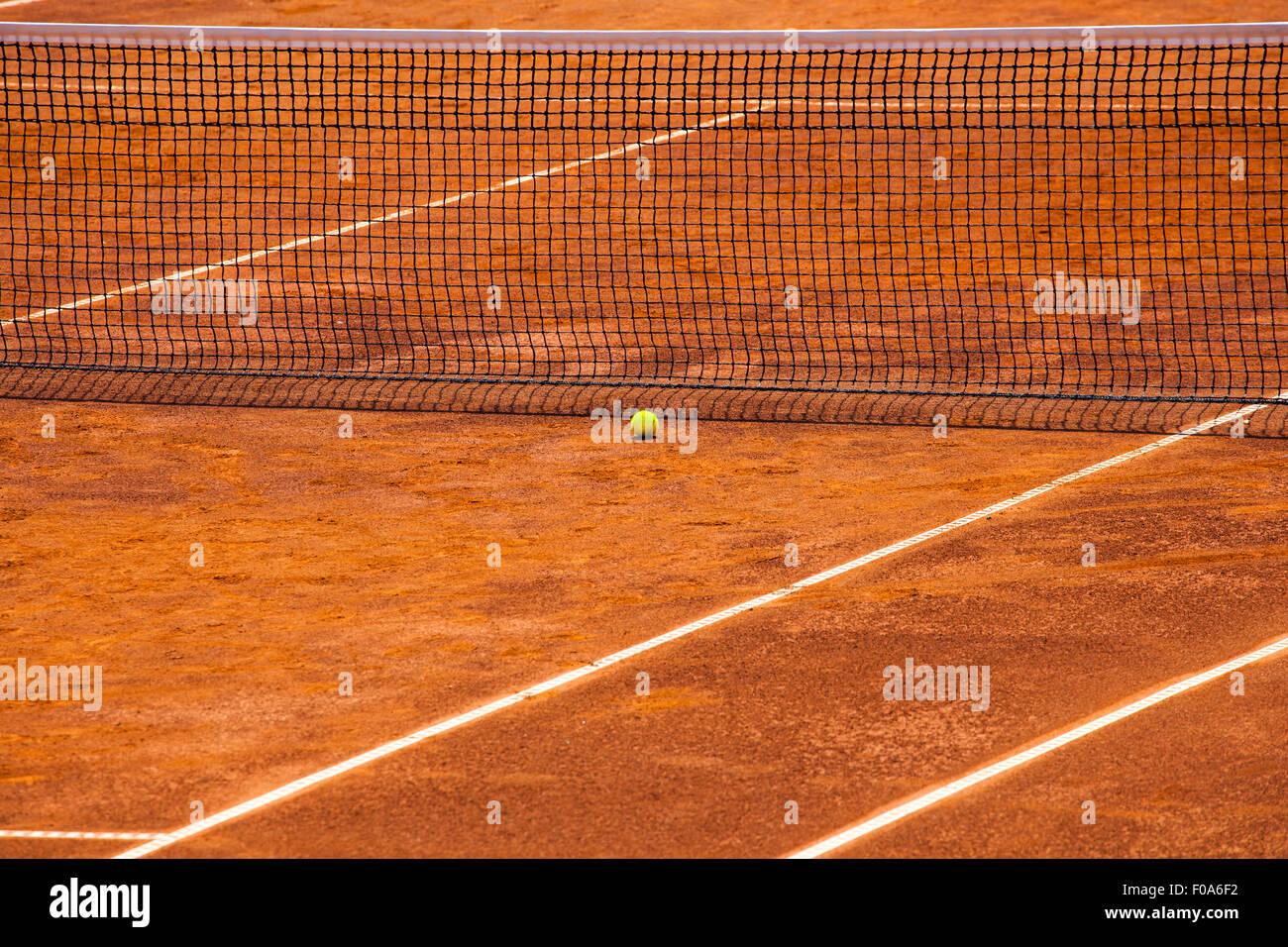Image d'un court de tennis avec filet et ballon jaune près de lui. Il s'agit d'une journée ensoleillée et la cour est prête avant Banque D'Images
