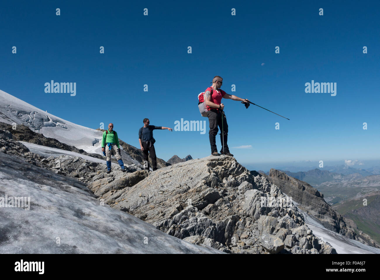 Les cavaliers sont de BASE Wingsuit escalade sur les rochers, entre le glacier et la neige pour trouver le point de saut et préparer leur costume. Banque D'Images