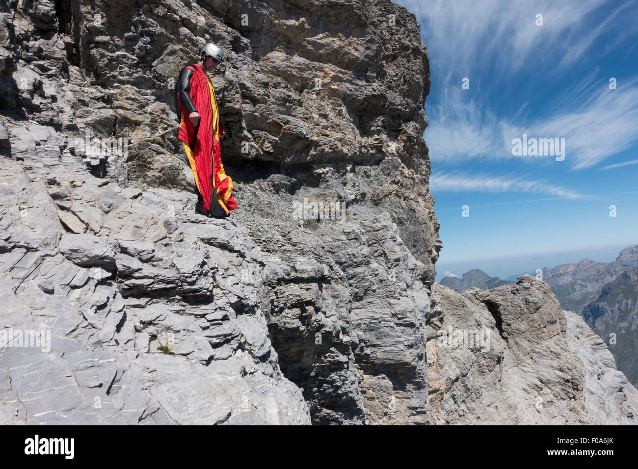 Cavalier BASE Wingsuit s'apprête à sauter d'une falaise et contrôle de l'altitude par vers le bas et réglage de ses ailes. Banque D'Images