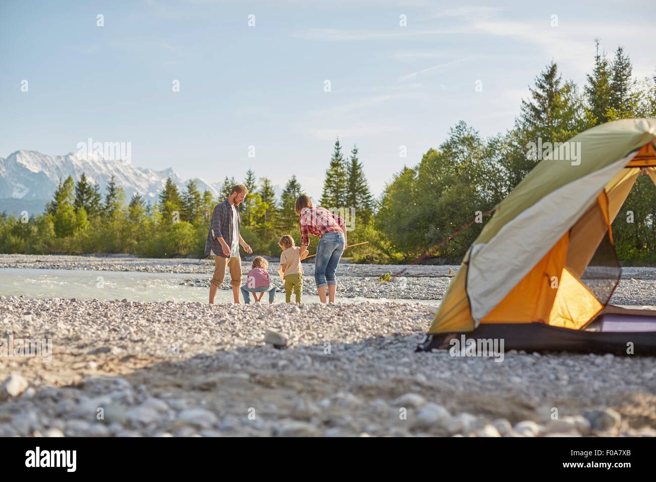 Vue arrière du family playing in river par tente, Wallgau, Bavière, Allemagne Banque D'Images