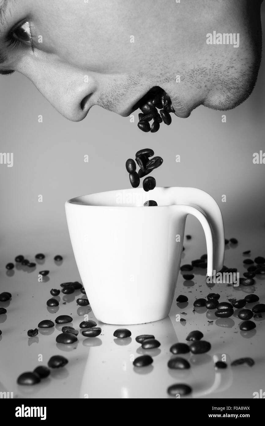 Personne crache grains de café dans la tasse de café Banque D'Images