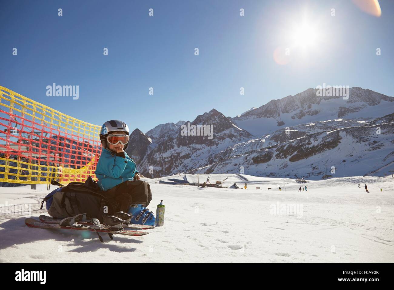 Portrait de la skieuse garçon assis sur sac à dos manger collation, Neustift, Stubaital, Tyrol, Autriche Banque D'Images