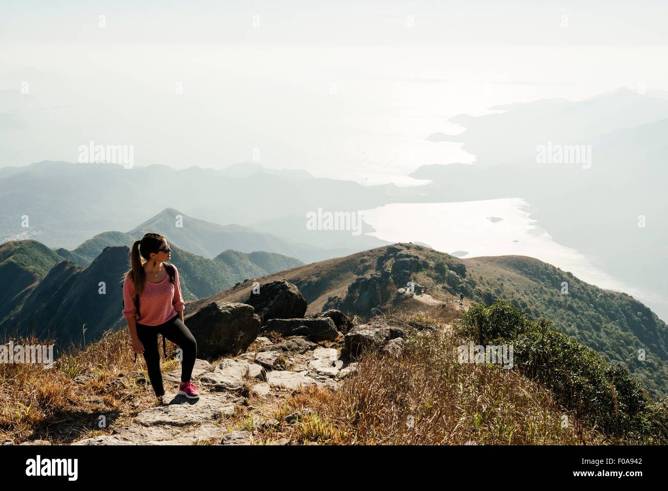 Jeune femme randonneur sur pic de Lantau à loin, Lantau Island, Hong Kong, Chine Banque D'Images