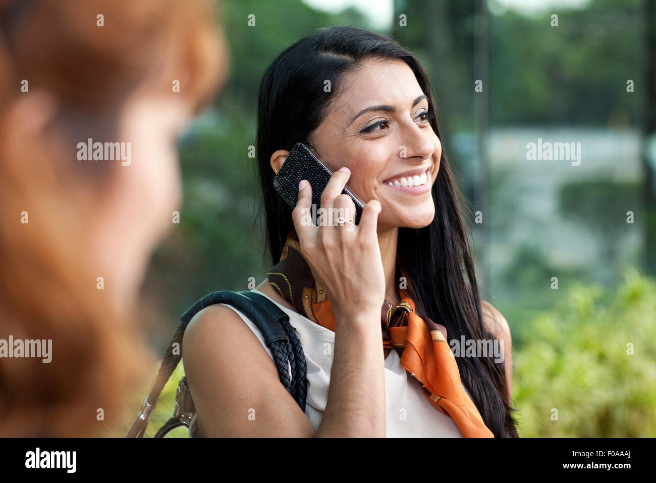 Mid adult woman using smartphone, smiling Banque D'Images