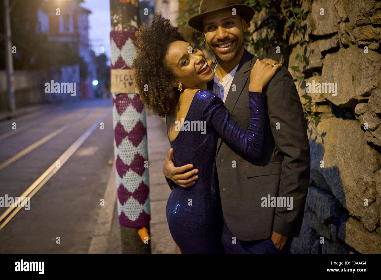 Portrait de couple hugging in street at night Banque D'Images