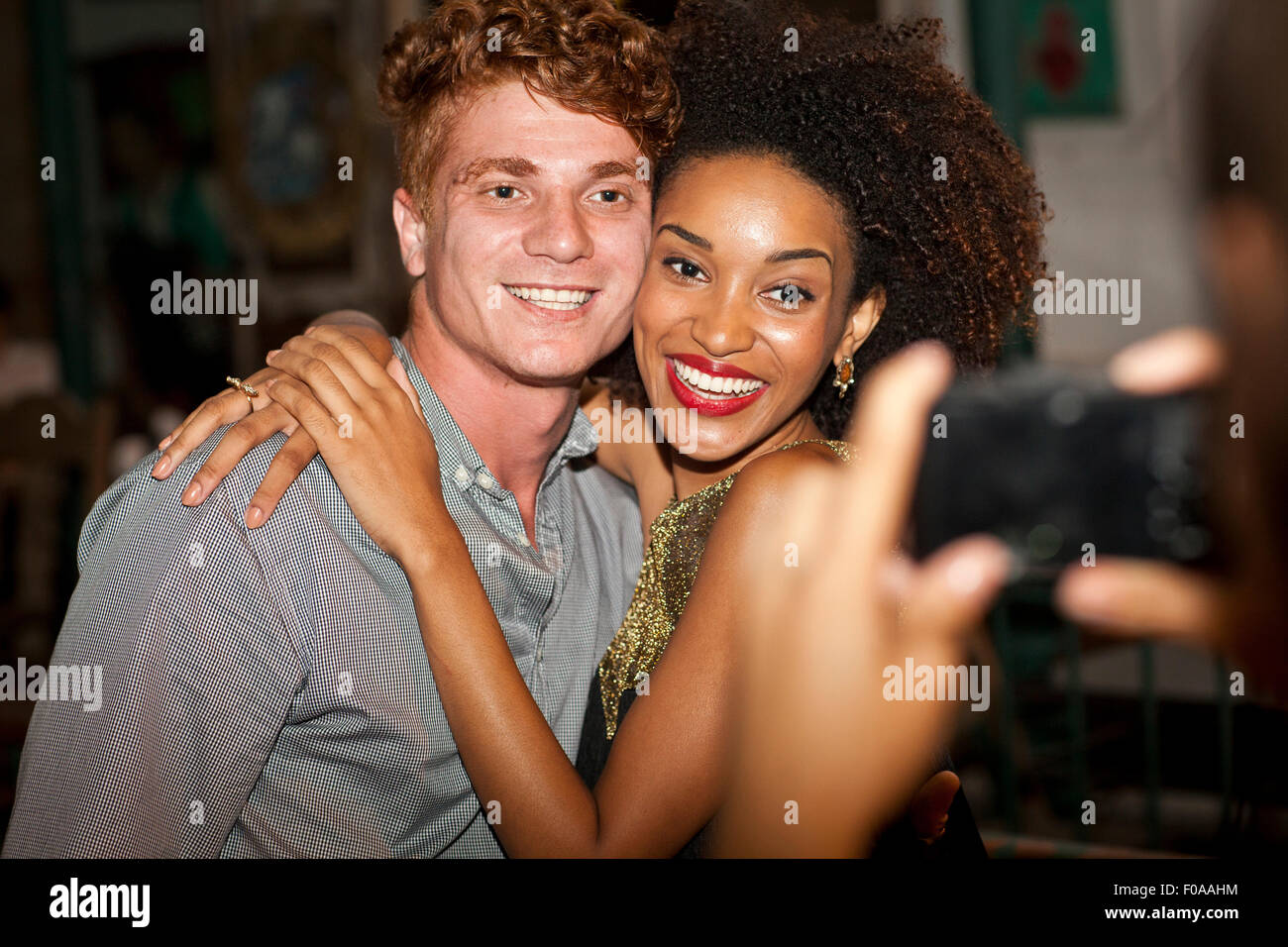Jeune couple ayant pris en photo en bar, smiling Banque D'Images