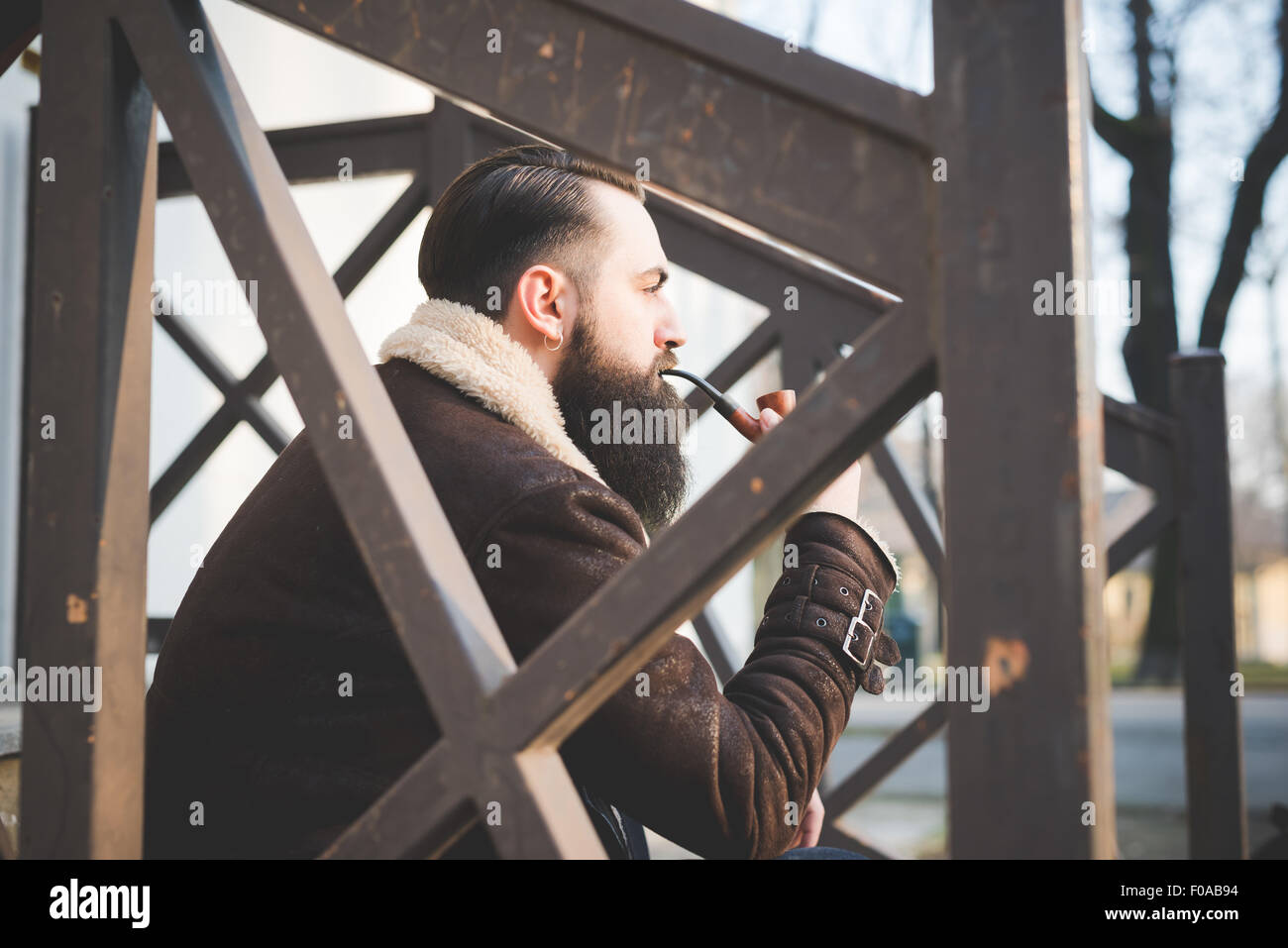 Jeune homme barbu pipe sur les mesures Banque D'Images