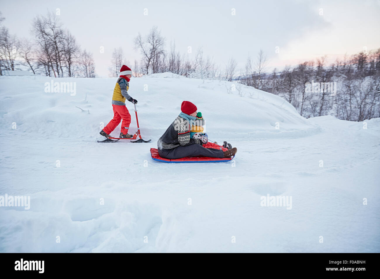 La mère et les deux fils de toboggan et scooter de neige sur la colline couverte de neige, Hemavan,Sweden Banque D'Images