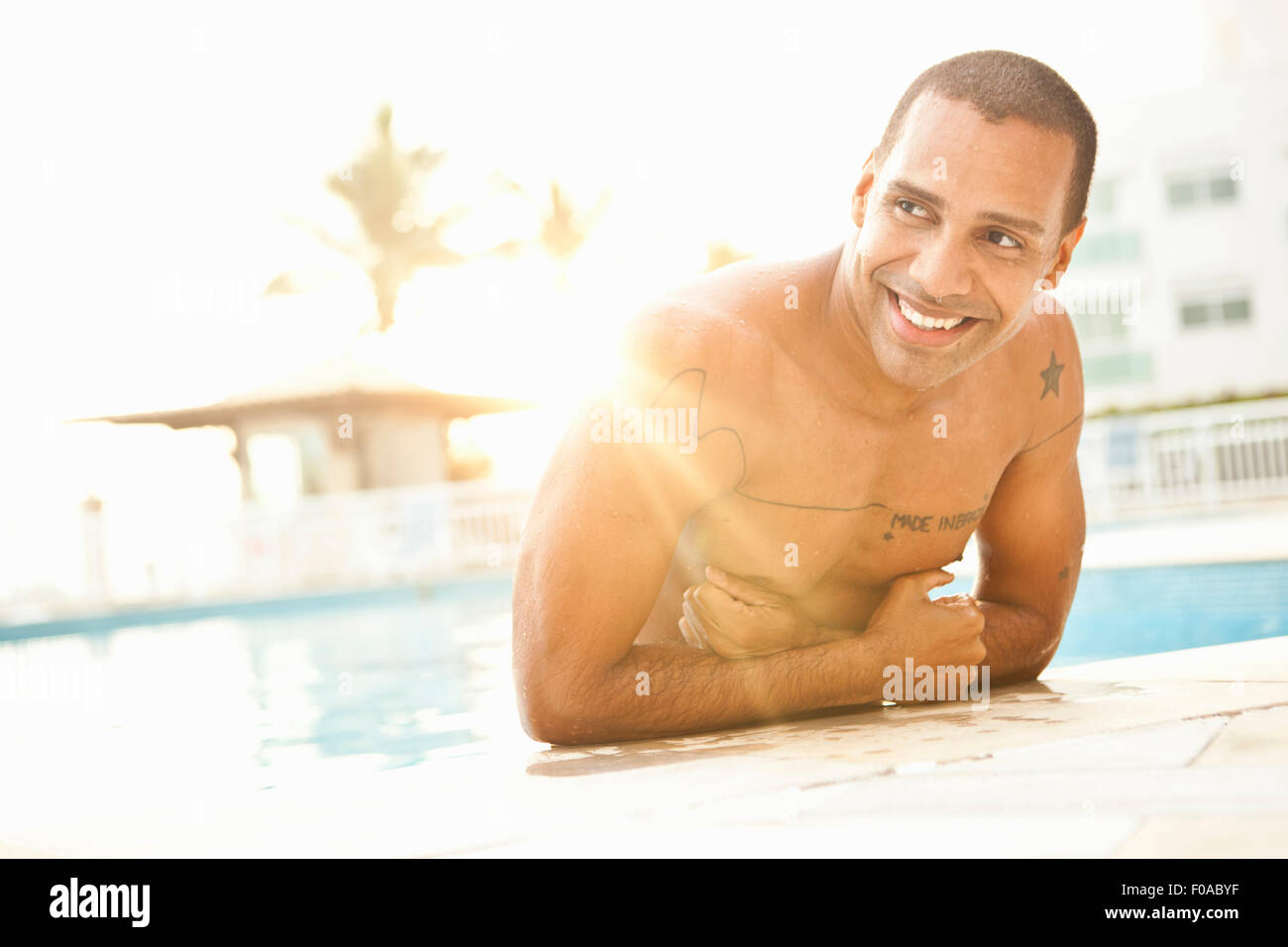 Mid adult man standing in sunlit piscine de l'hôtel, Rio de Janeiro, Brésil Banque D'Images