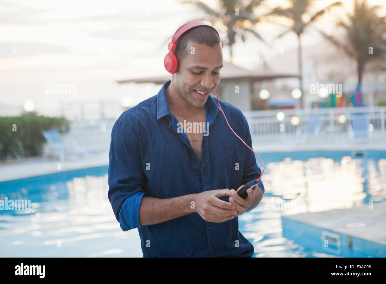 Mid adult man sélection musique smartphone à l'hôtel, au bord de Rio de Janeiro, Brésil Banque D'Images