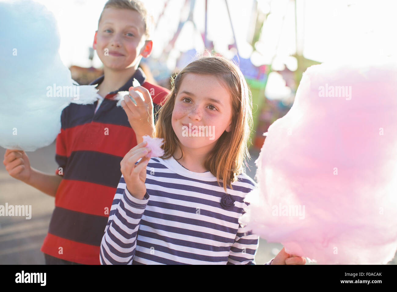 Frère et soeur Rose manger candyfloss à fairground Banque D'Images