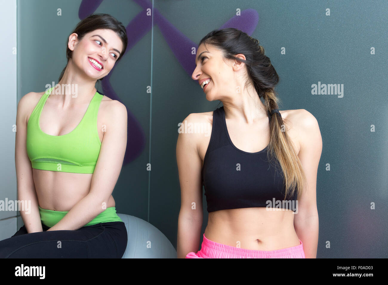 Deux jeunes femmes à la recherche à l'autre et smiling in gym Banque D'Images