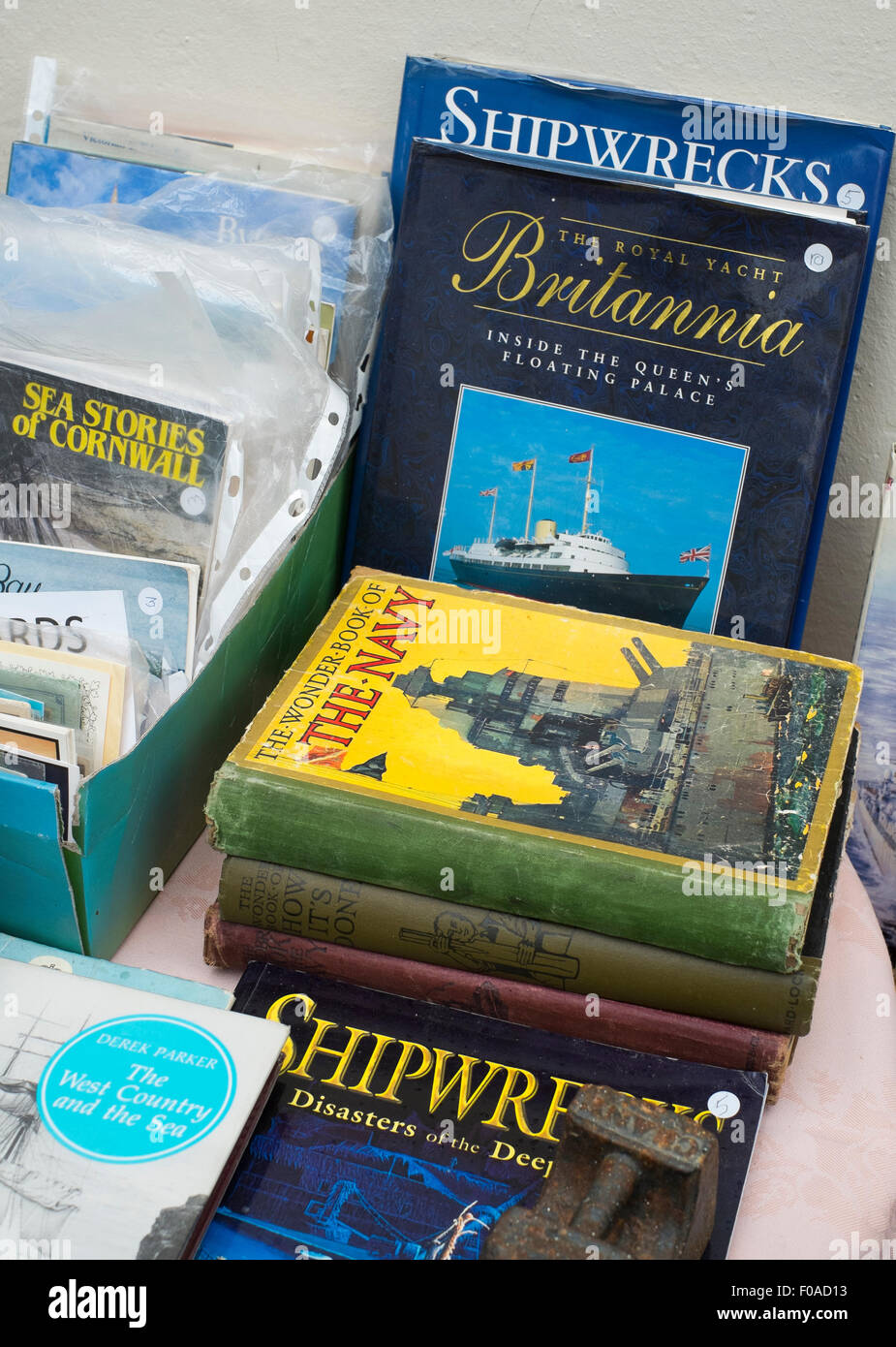 Vieux livres de marine sur l'affichage dans une vitrine à Fowey, Cornwall, England, UK. Banque D'Images