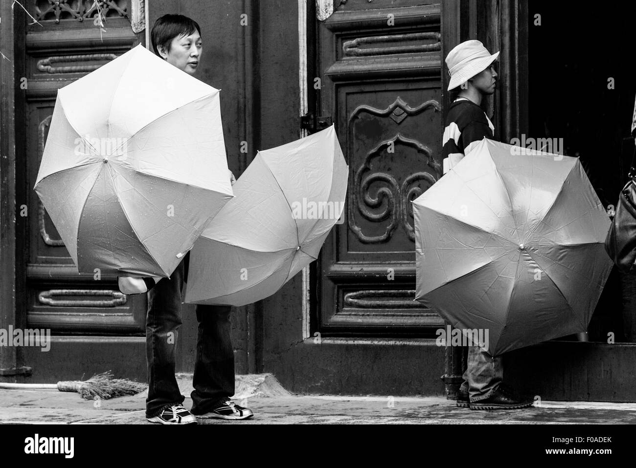 Les gens d'attendre à l'extérieur du Temple du Lama (Yong Il Gong) avec parasols, Beijing, Chine Banque D'Images