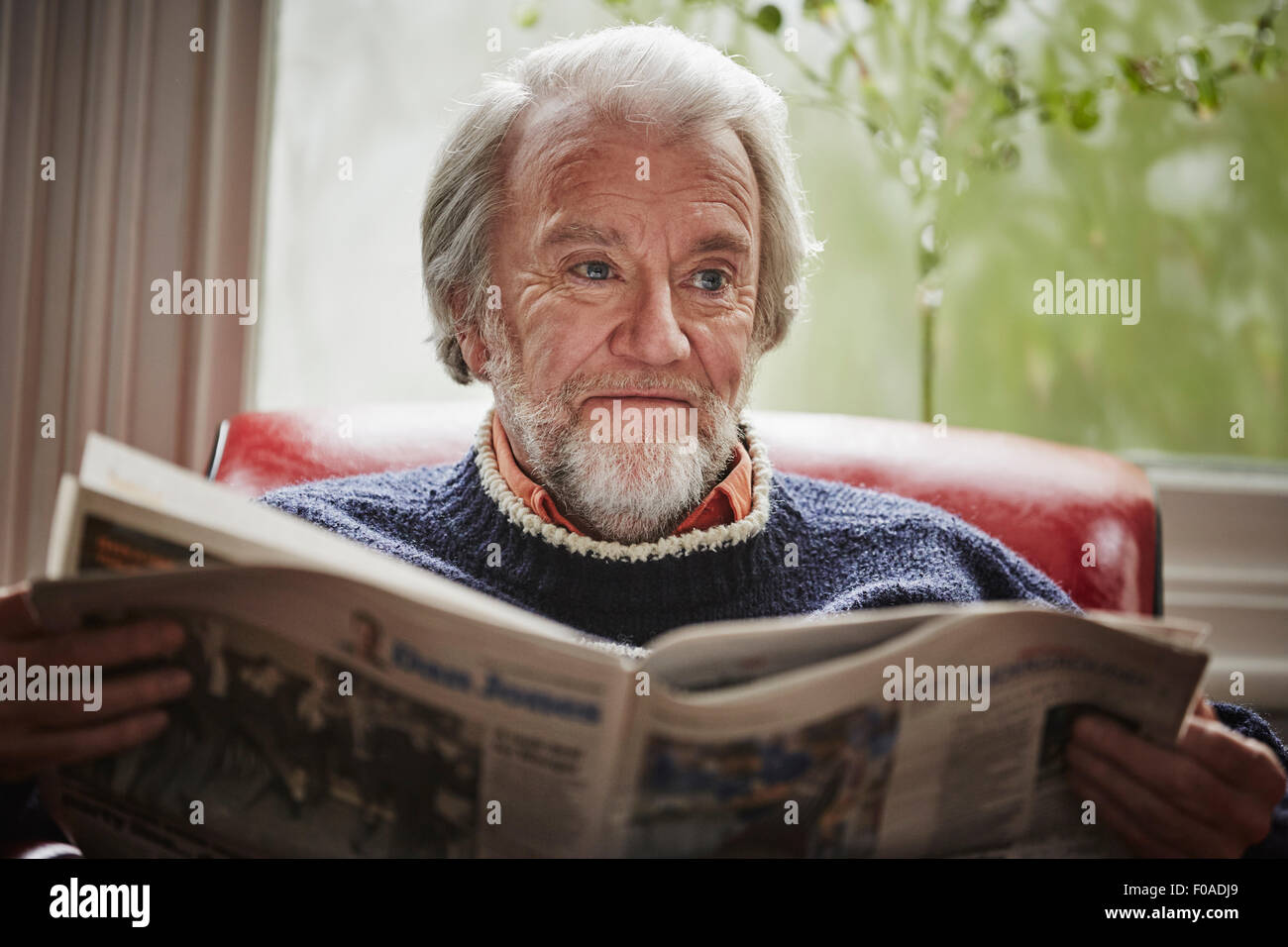 Senior man reading newspaper Banque D'Images