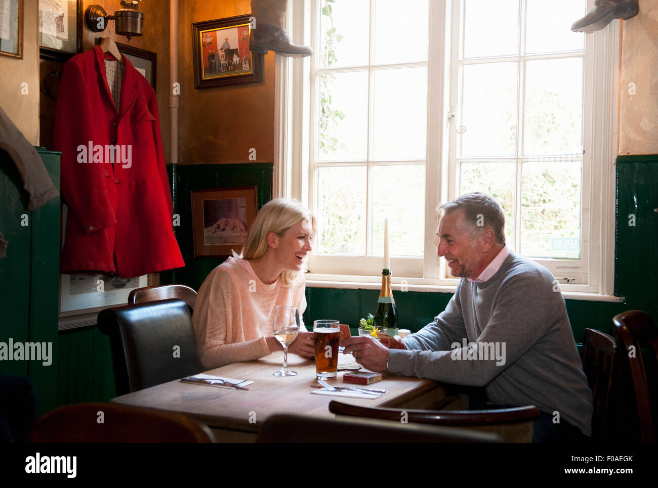Couple drinking et bavarder dans pub Banque D'Images Couple drinking et bavarder dans pub Banque D'Images