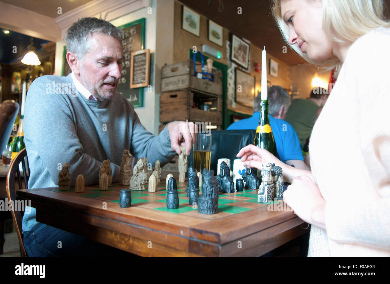 Couple jouant aux échecs dans un pub Banque D'Images
