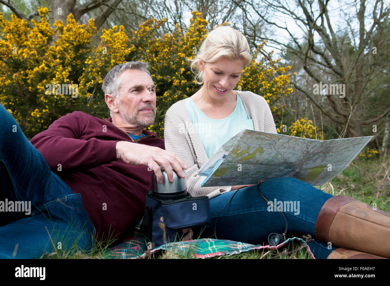 Randonnées couple picnicing et reading map Banque D'Images Randonnées couple picnicing et reading map Banque D'Images