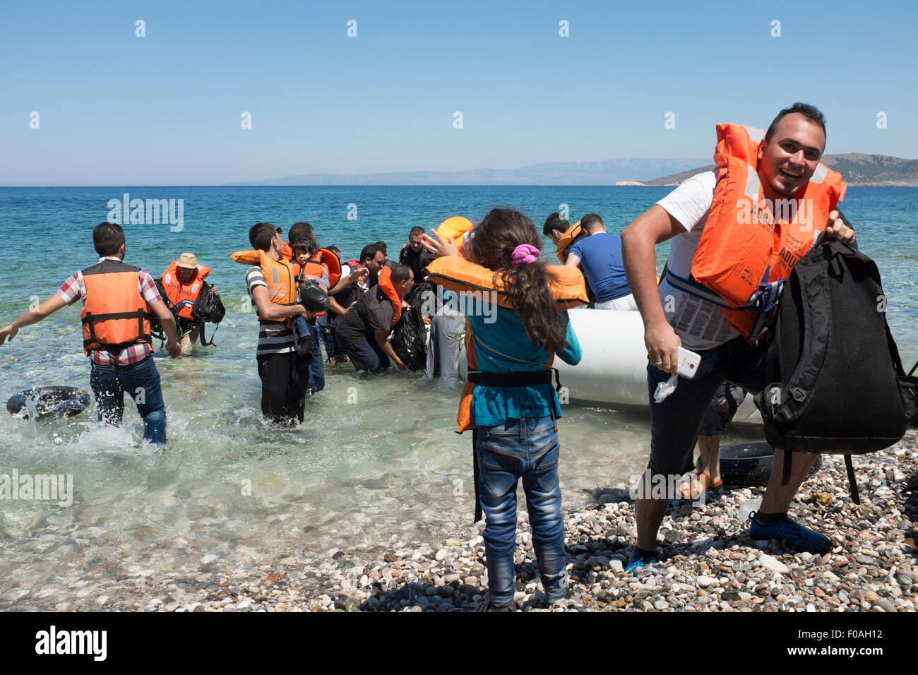 Chios, Grèce. 21 juillet, 2015. Les réfugiés en provenance de Syrie arrivent dans overladen canot en caoutchouc sur l'île grecque de Chios. Les 60 occupants du bateau sont arrivés après 5 heures en mer et trois jours à pied soulagés et heureux de poser le pied sur le sol européen après une évasion de la combattre en Syrie. Chios, Grèce. Crédit : Mike Abrahams/Alamy Live News Banque D'Images