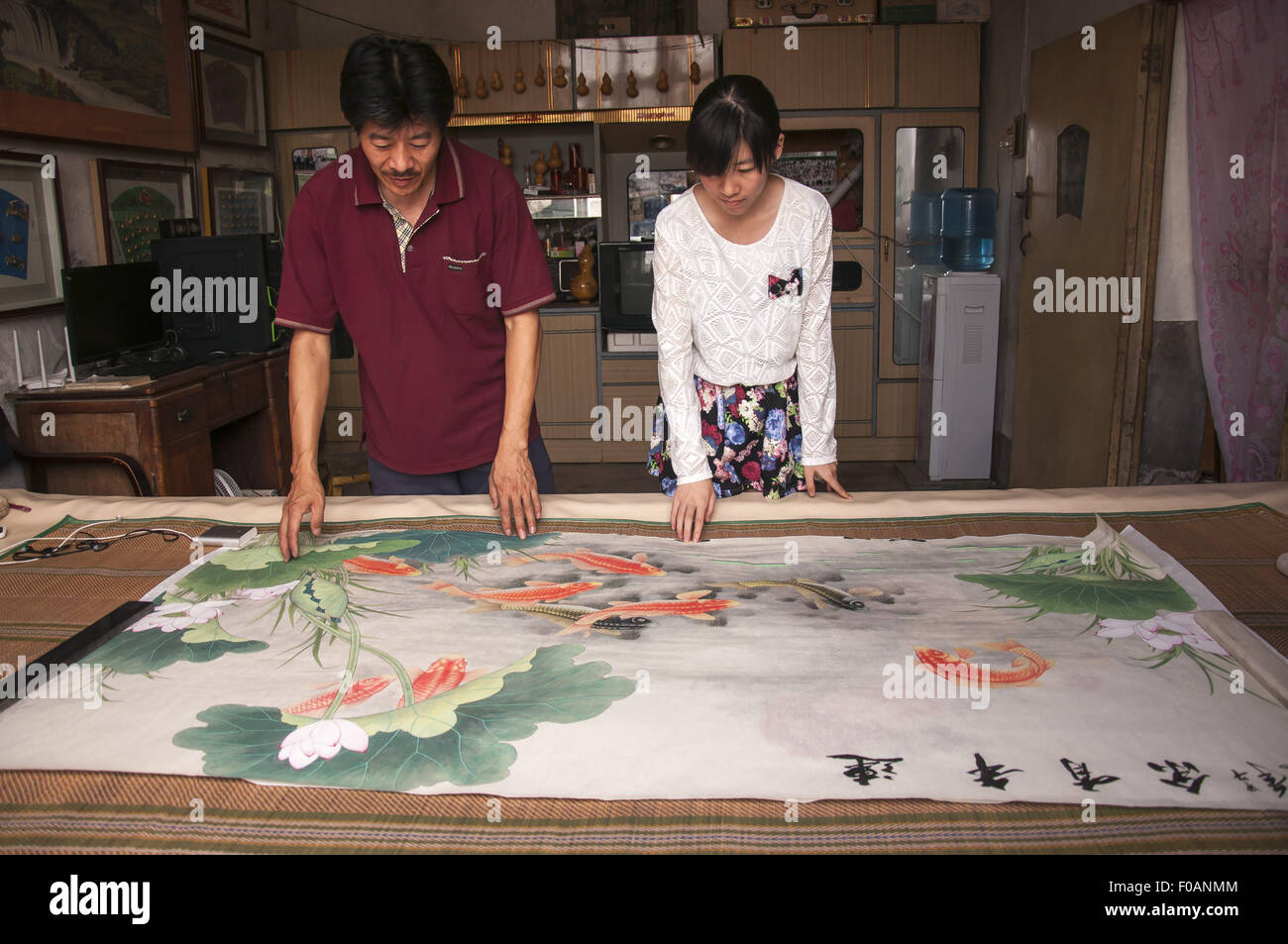19 juillet 2015 - Huanghua, Hebei, Chine, Huanghua RCS - - le 19 juillet 2015 : (usage éditorial uniquement. Chine OUT) sa fille s'intéresse à la peinture traditionnelle chinoise. Du Baojiao, une fishman vit en Jijiabao Lianhuafeng Huanghua Village, écrit des poèmes et attirer oftens peintures faciales sur des coquilles de crabe. Il lui apporte l'argent et l'aider à exprimer son amour pour la mer. Chaque coquille de crabe doit être nettoyé, séché, en forme, et ces précédents travaux sont finis par sa femme et sa fille. Quelques poissons du donc il n'a soulevé quelques cochons pour une vie. Dernièrement il a soulevé moins de porcs depuis plus de clients viennent pour acheter ces douleur Banque D'Images