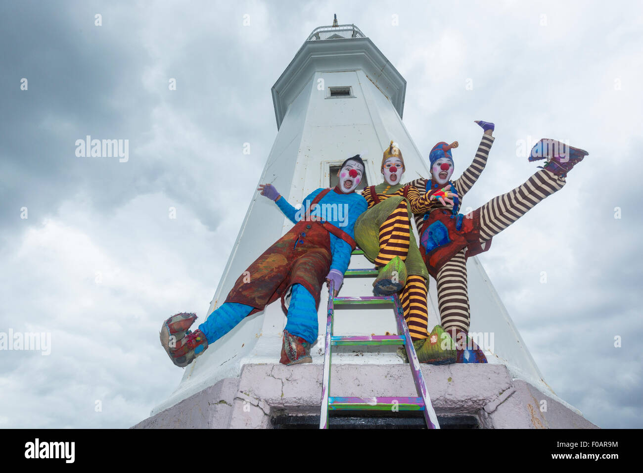 Edinburgh, Royaume-Uni. Août 11, 2015. Cazzo (jaune hat), Lazzo (chapeau  bleu) et Pazzo (haut bleu) solde autour du phare de Newhaven. Leur  spectacle 'Vagabond, où le vent vous ?' fait partie de