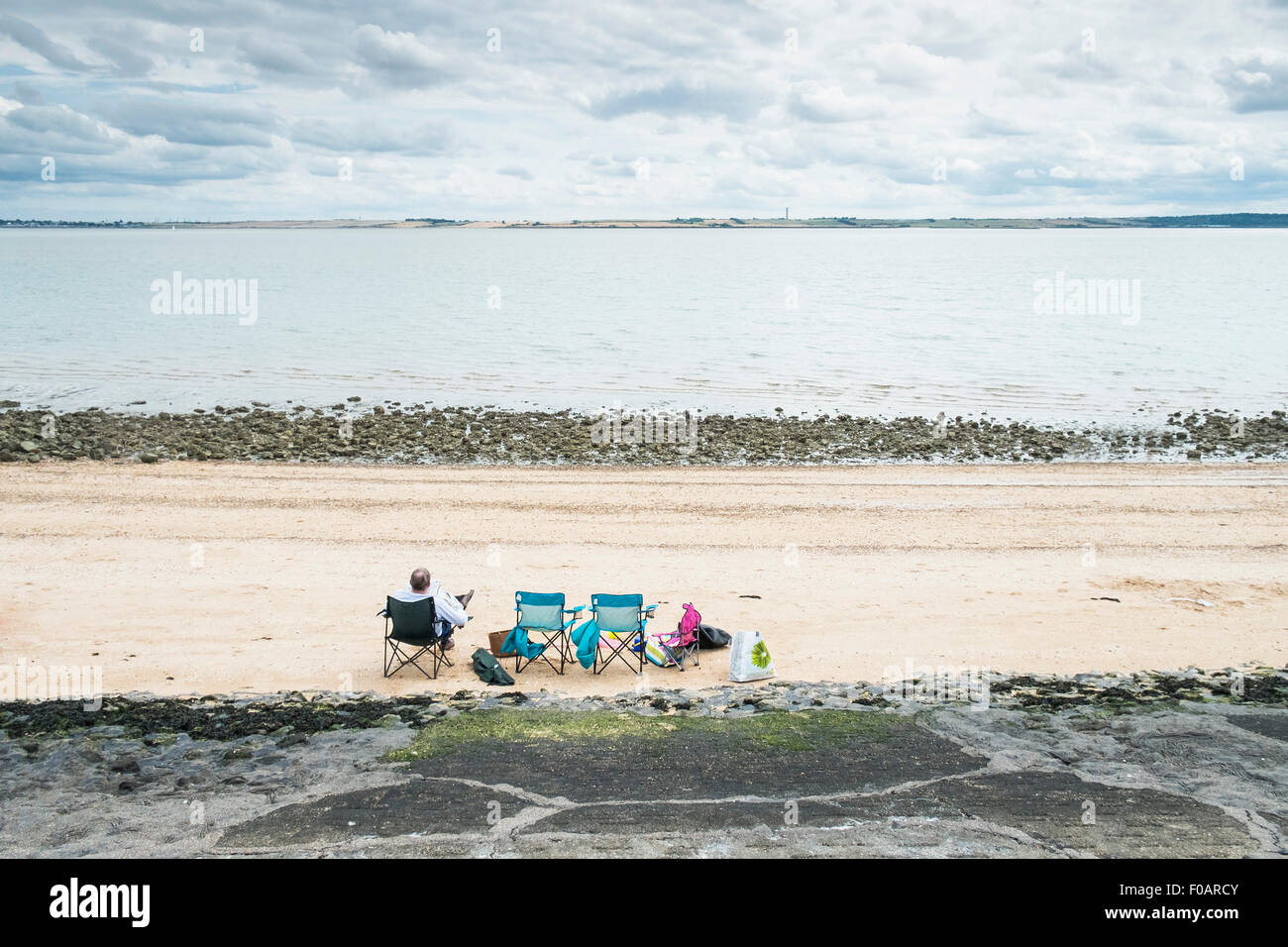Southend - Un homme se détendre sur la plage de Southend-on-Sea, Essex. Banque D'Images