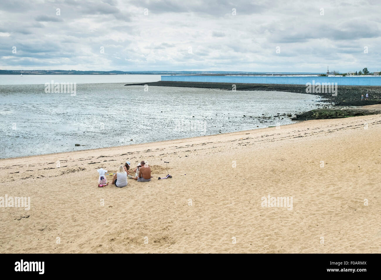 Southend - une famille de vous détendre sur la plage à Thorney Bay sur Southend, Essex. Banque D'Images