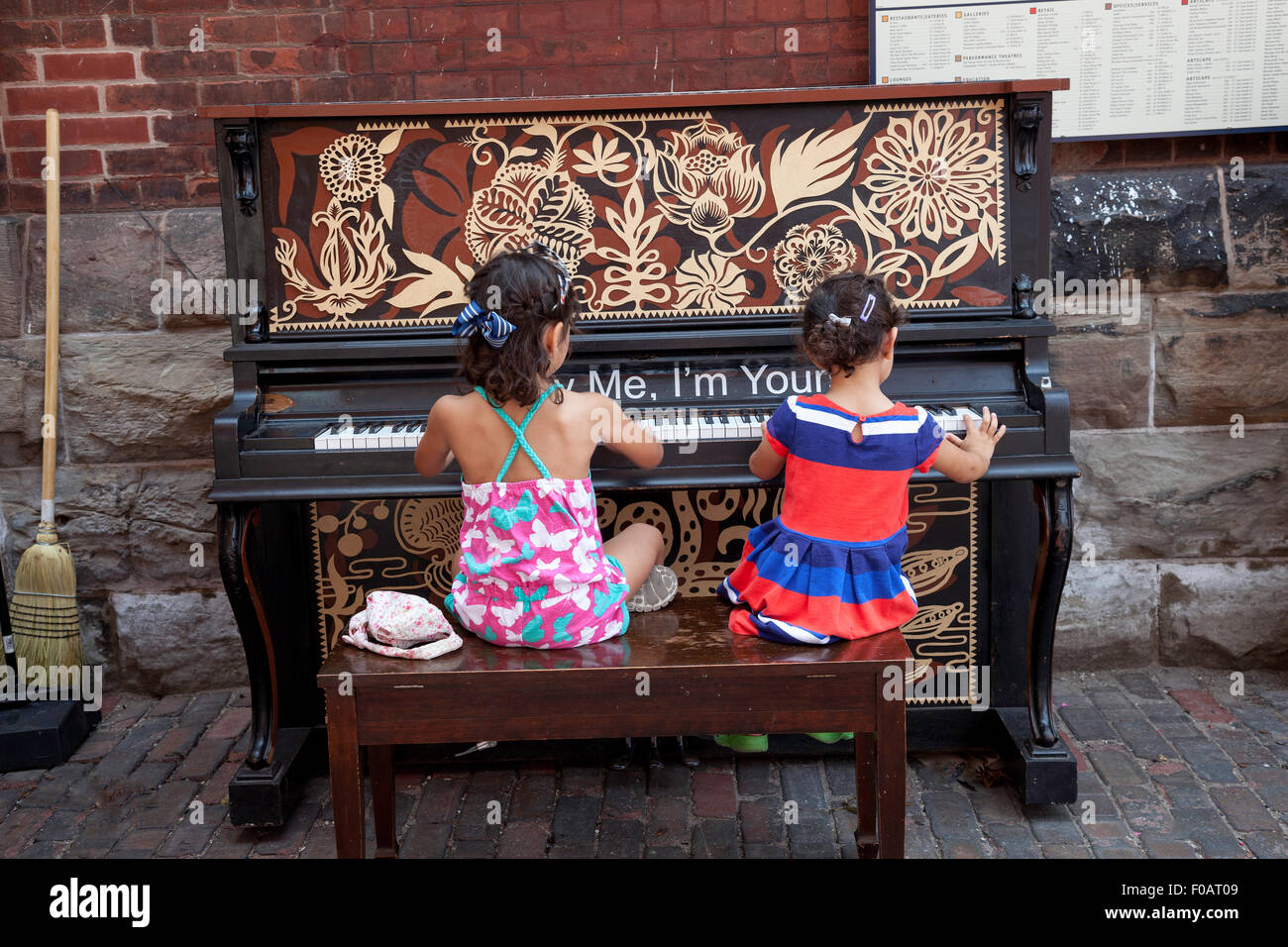 Deux jeunes enfants jouant un piano à l'extérieur à la Distillery District de Toronto;Ontario;Canada Banque D'Images