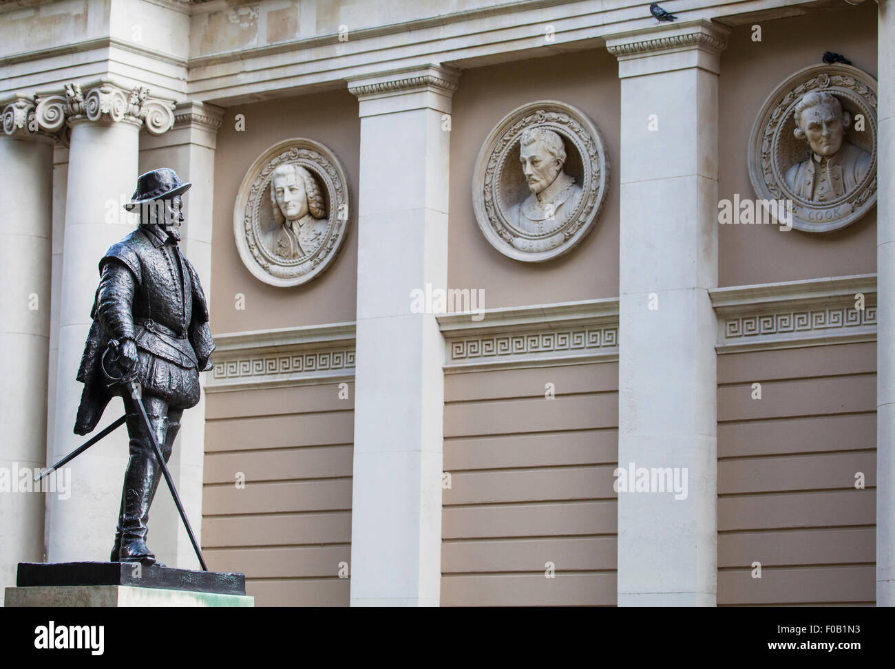 Statue de Sir Walter Raleigh avec des bustes de célèbres figures de la Marine royale à l'arrière-plan. Banque D'Images