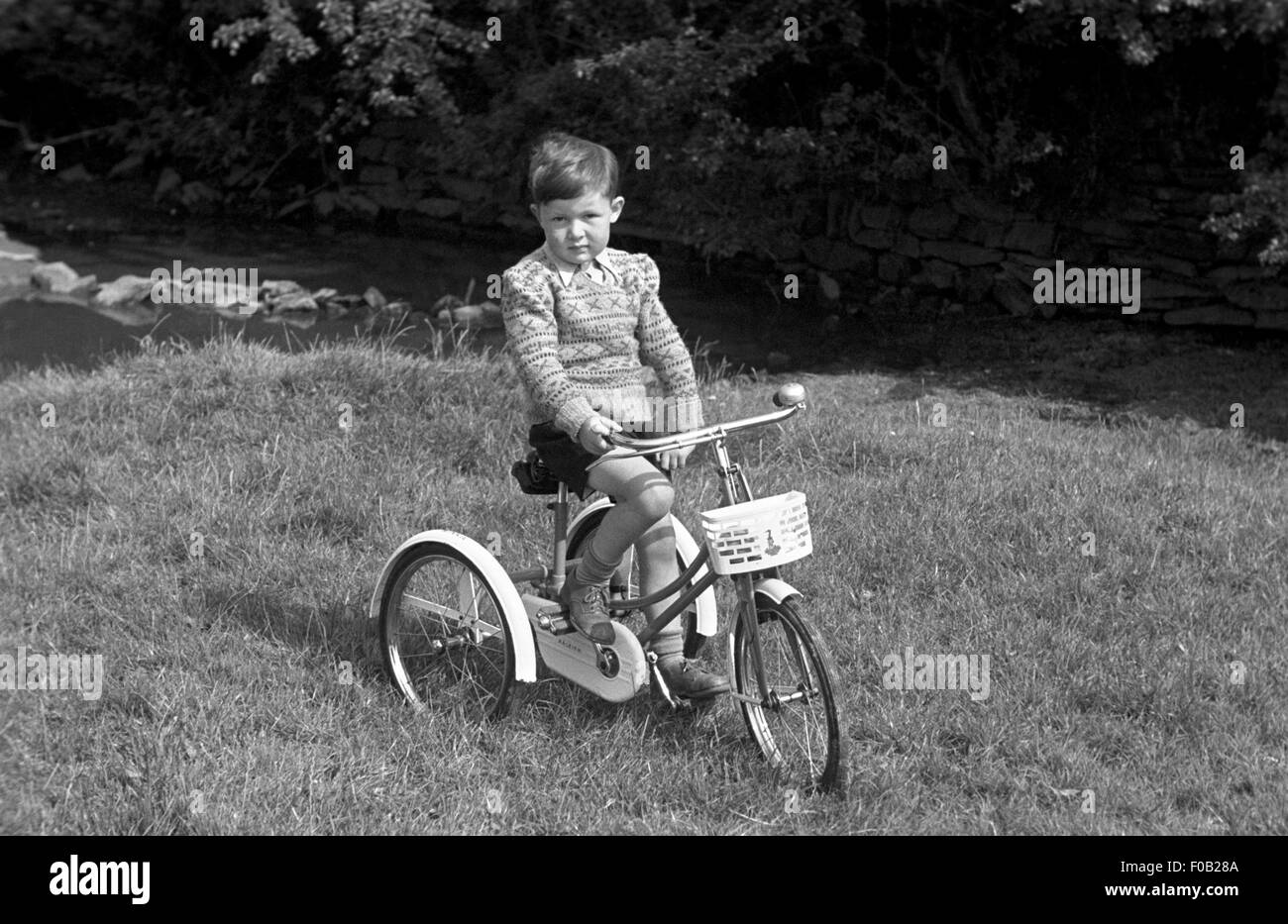 Portrait d'un garçon sur un tricycle Banque D'Images