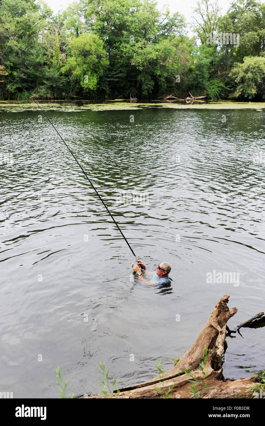 La rivière du Lot dans la région Midi-Pyrénées France Europe de l'homme jusqu'à son cou la pêche dans la rivière après avoir chuté en Banque D'Images