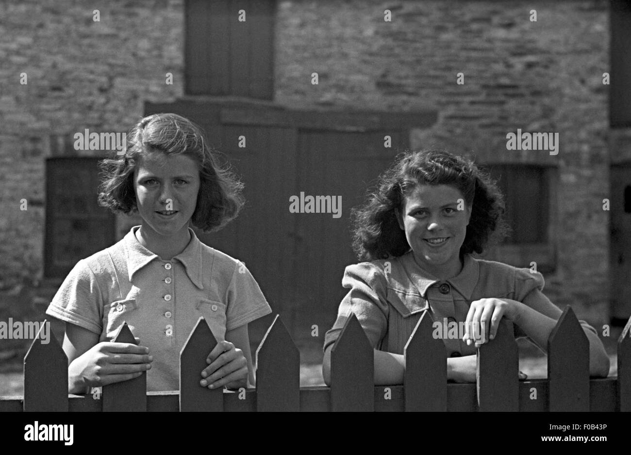 Deux femmes debout à côté d'une clôture. Banque D'Images