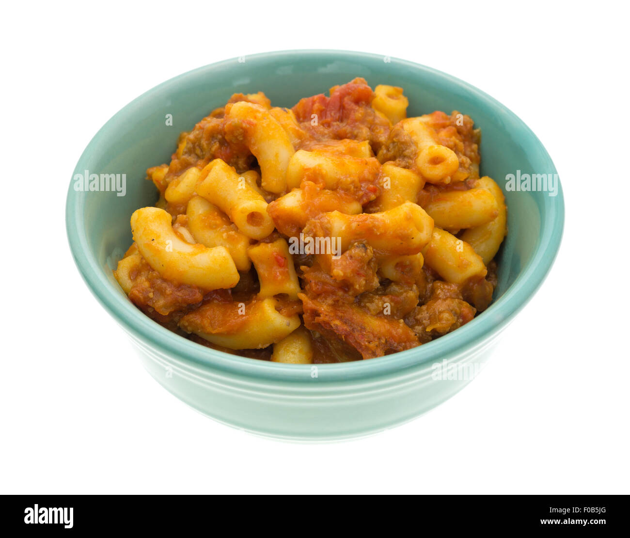 Un boeuf cuit et repas de macaroni dans un petit bol vert isolé sur un fond blanc. Banque D'Images