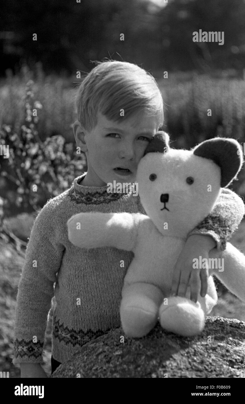 Un petit garçon aux cheveux juste regardant la caméra avec son bras autour  de sa peluche Photo Stock - Alamy