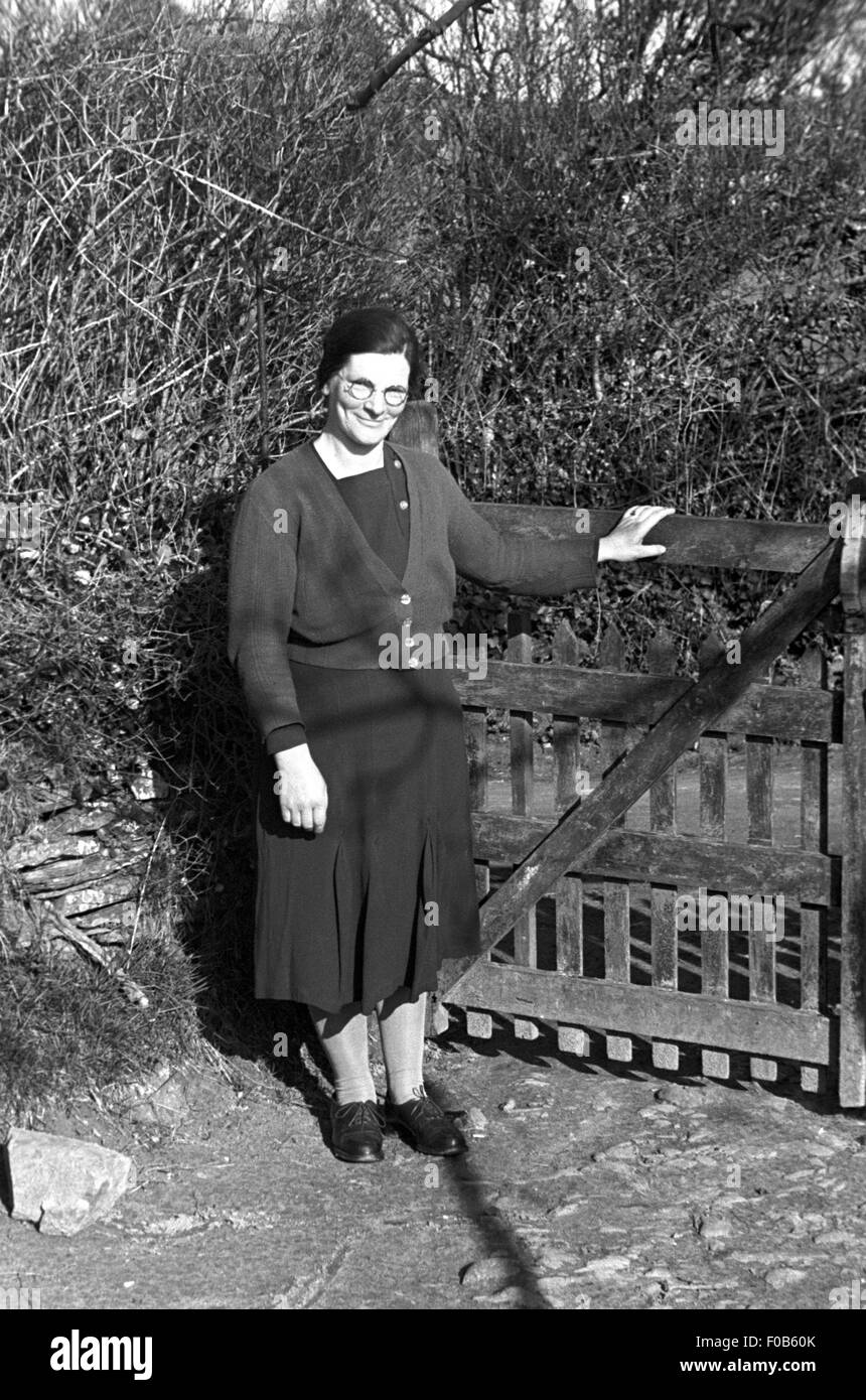 Une femme d'âge moyen dans une robe debout à une porte Banque D'Images