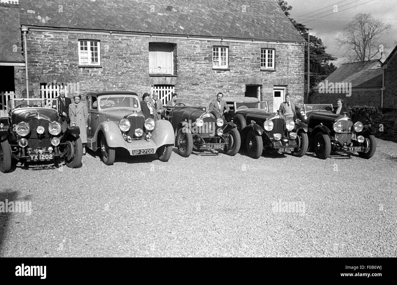 Une gamme de voitures Bentley et leurs propriétaires à l'extérieur d'une maison dans le pays. Banque D'Images