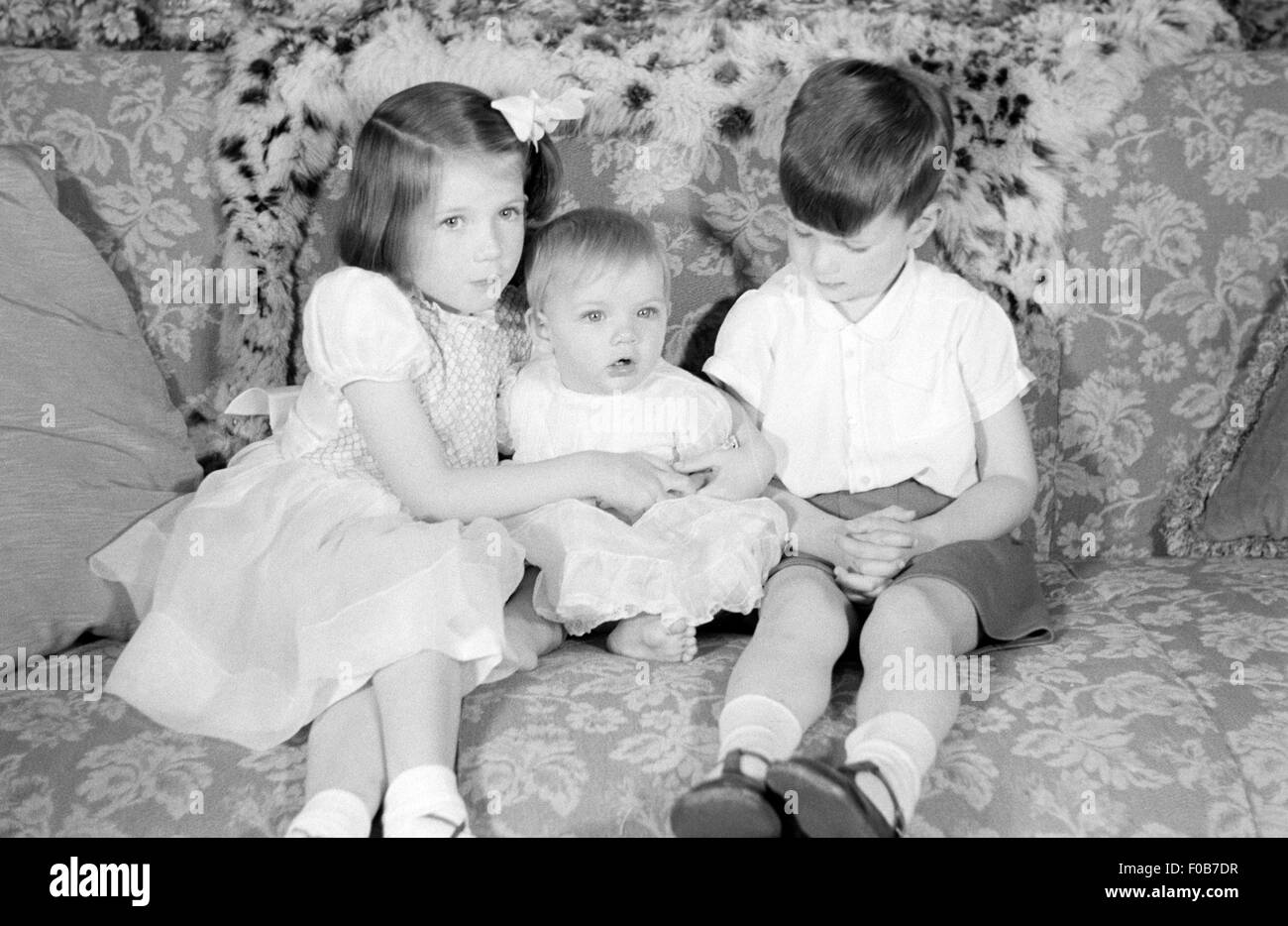 Trois enfants assis sur un canapé Banque D'Images