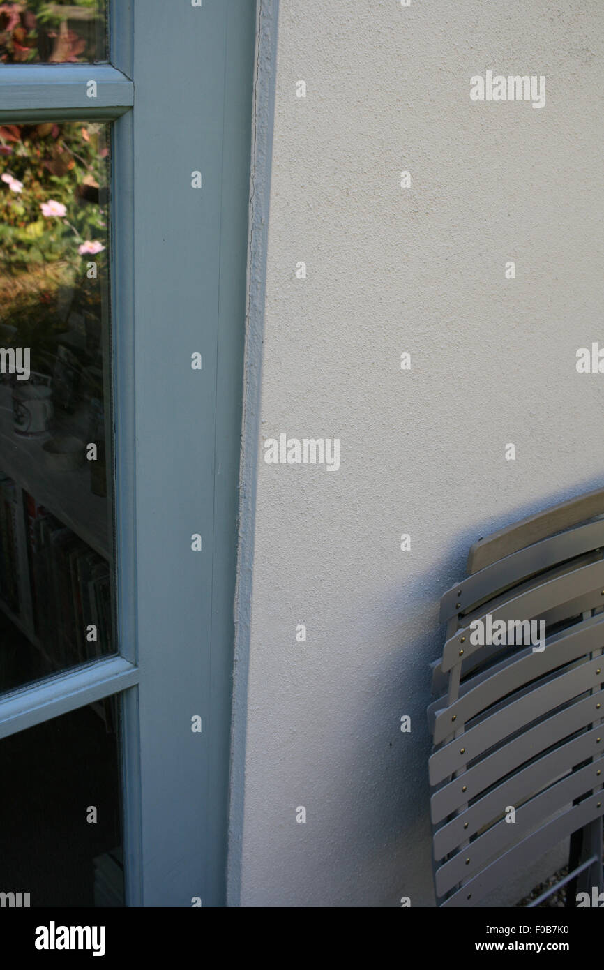 Rendu mur peint en blanc, bleu avec portes françaises et chaises bistrot gris appuyé contre le mur Banque D'Images